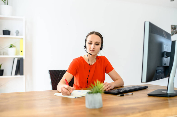Žena používající sluchátka a PC pro práci - Fotografie, Obrázek