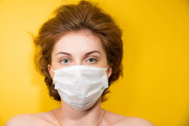 Close-up Portrait of a young woman in a medical mask protecting against the coronavirus pandemic, face protection against the spread of the covid-19 virus, epidemic concept - Foto, afbeelding