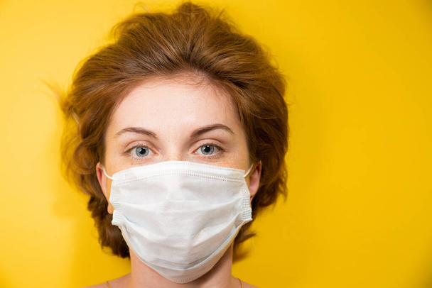 Close-up Portrait of a young woman in a medical mask protecting against the coronavirus pandemic, face protection against the spread of the covid-19 virus, epidemic concept - Foto, Bild