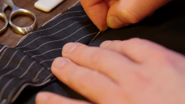 テーラリングの伝統:古代の伝統によると、針と糸で若いテーラーメイドの手縫いのプロの動き - 映像、動画