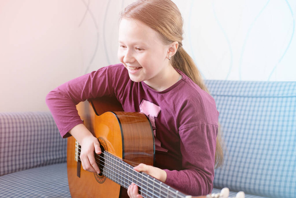 happy active girl playing guitar.  - Фото, изображение