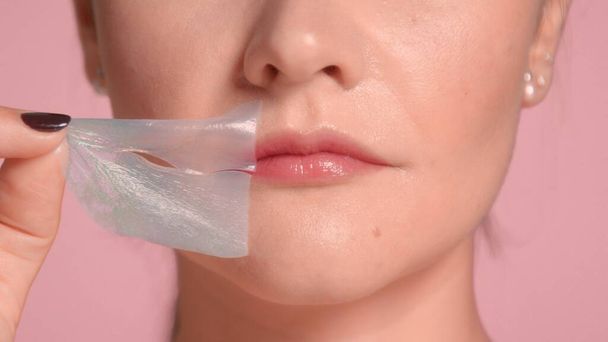 nierozpoznawalne kobiety usta zbliżenie zdejmuje jej plaster ust - Zdjęcie, obraz