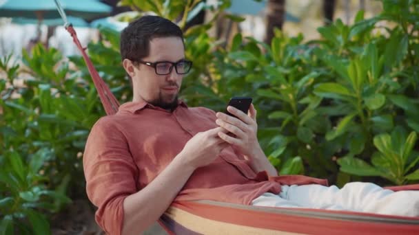 Loisirs en plein air avec smartphone dans hamac
 - Séquence, vidéo