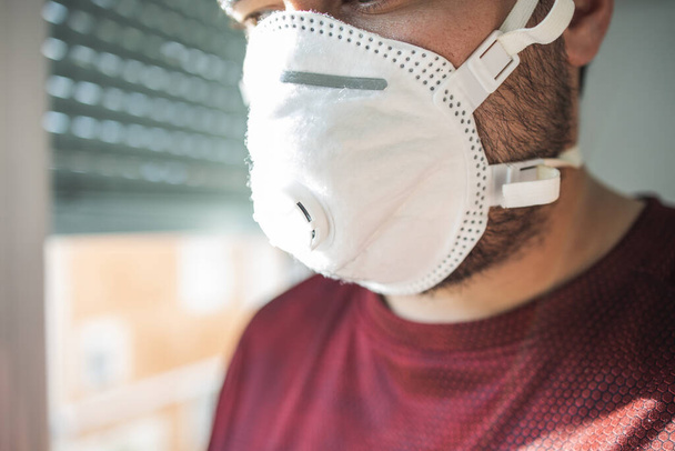 Man with surgical mask due to pandemic in home - Foto, Imagem