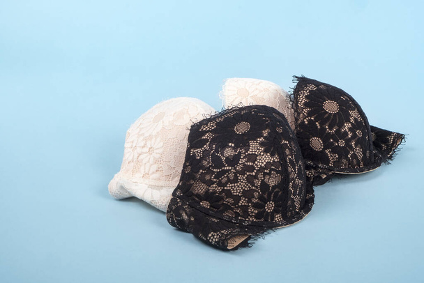 Light Pink and Black Lace Bras with Floral Pattern on Baby Blue - Photo, Image