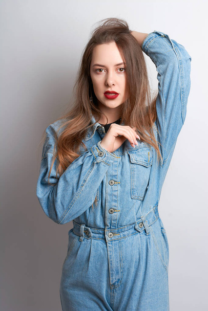 beautiful girl with red lipstick in a denim suit on a white background.girl's emotions - Valokuva, kuva