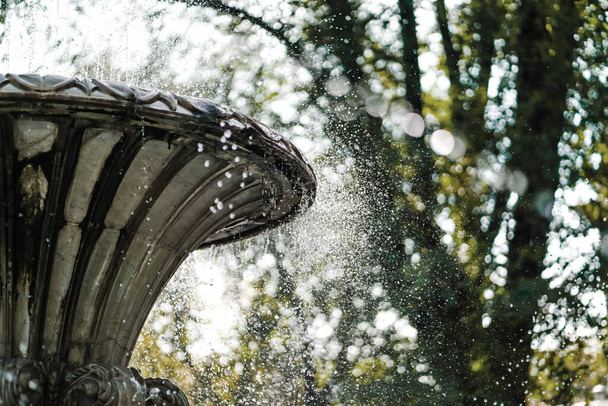 Brunnen in der Stadt. Wassertropfen. plätschert aus einem Brunnen vor dem Hintergrund des sonnigen Himmels. Stadtarchitektur. - Foto, Bild