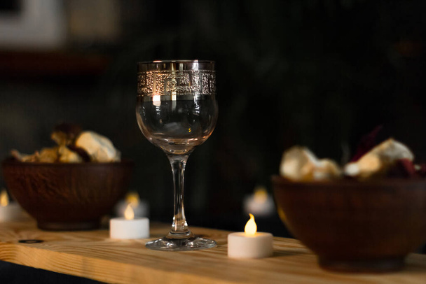 Ein entspannter Abend mit Kerzen, Wein und Aromen. Glasbecher auf dem Tisch. Rosenblätter. Romantischer Abend - Foto, Bild