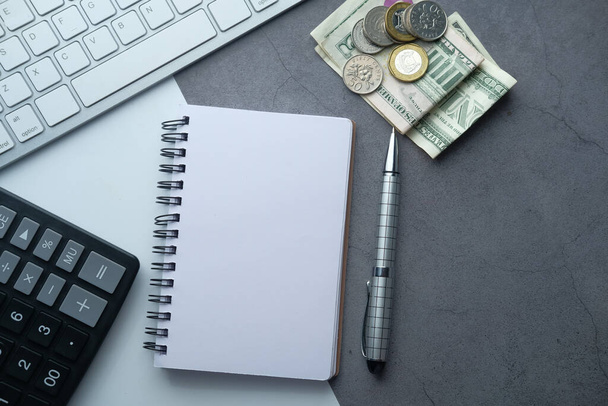 Masadaki not defteri, para ve klavyenin üst görünümü . - Fotoğraf, Görsel