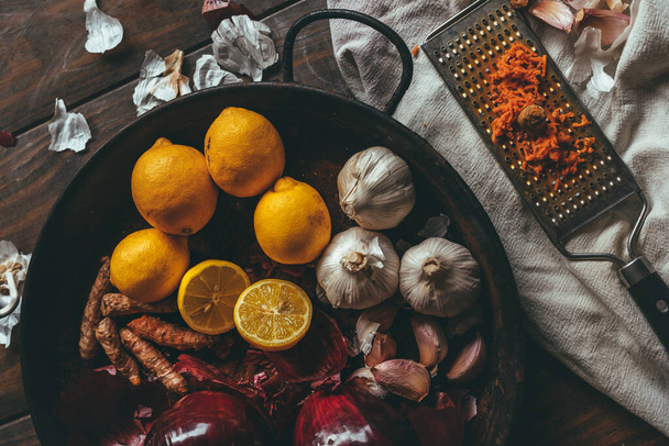 Paella com cebola, alho, limão e açafrão ralado em uma mesa de madeira rústica
 - Foto, Imagem