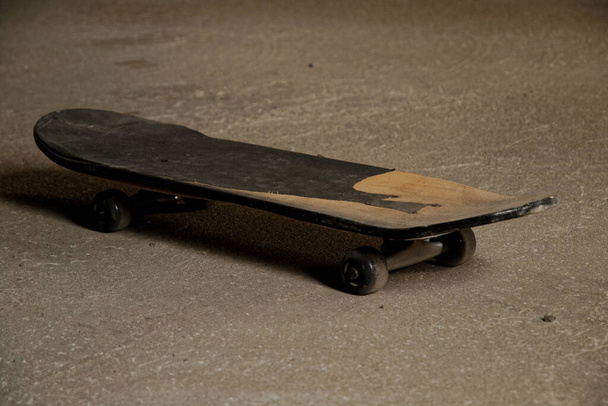 старий скейтборд на бетонній підлозі в гаражі. спортивна концепція. крупним планом
 - Фото, зображення