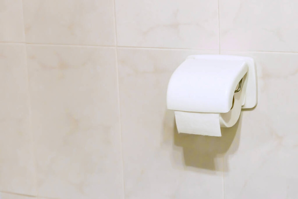 WC tekercs csatlakozik a falra a fürdőszobában. Személyi higiénia, egészségügyi koncepció.  - Fotó, kép