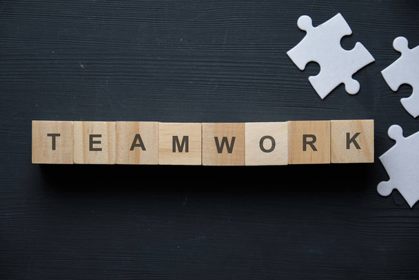 Modern business buzzword - teamwork. Top view on wooden table with blocks. Top view. Close up. - 写真・画像