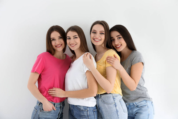 Beautiful young ladies in jeans and colorful t-shirts on white background. Woman's Day - Valokuva, kuva