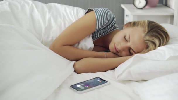 Young beautiful woman waked up by phone call in the morning - Video, Çekim