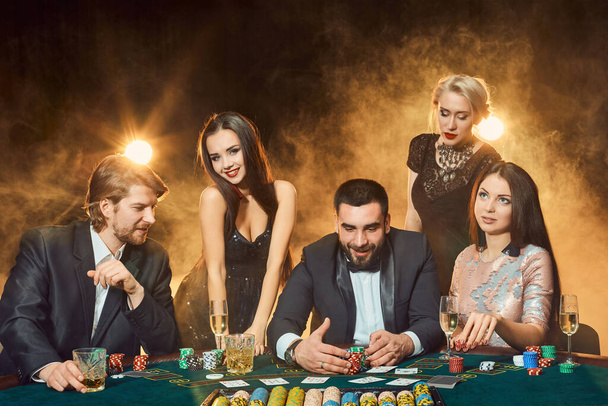 ポーカープレーヤーはカジノのテーブルの周りに座っています。ポーカーだ。ギャンブルだ。カジノ - 写真・画像