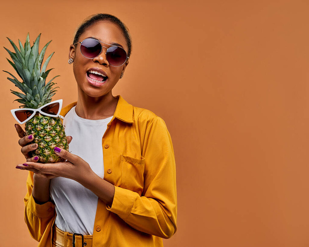 Happy lady with sunglasses with earrings with a pineapple in white sunglasses. - Zdjęcie, obraz