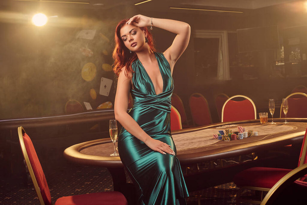 Jeune belle femme pose contre une table de poker dans un casino de luxe
. - Photo, image