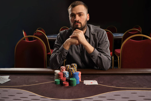 Schöner bärtiger Mann pokert am Tisch im Casino. - Foto, Bild