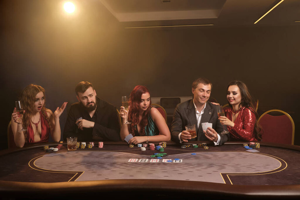 Group of a young rich friends are playing poker in casino. - Foto, Imagem