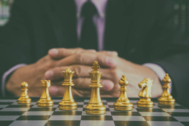 Chess game on chess board behind business man background. Business concept to present financial information and marketing strategy analysis. Investment target in global economy and digital commercial. - Foto, immagini