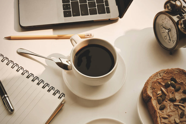 Καφές φλιτζάνι ζεστό και φορητό υπολογιστή στυλό εργασίας από το σπίτι την ημέρα το πρωί - Φωτογραφία, εικόνα