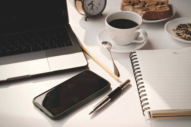 Koffiebeker warm en laptop pen werk van thuis uit in de ochtend dag - Foto, afbeelding