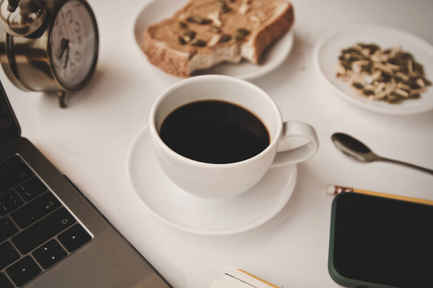 Café taza caliente y portátil pluma trabajo desde casa en el día de la mañana
 - Foto, imagen
