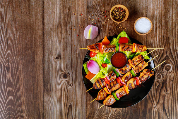 Grilled chicken on wooden skewer with hot sauce. - Photo, Image