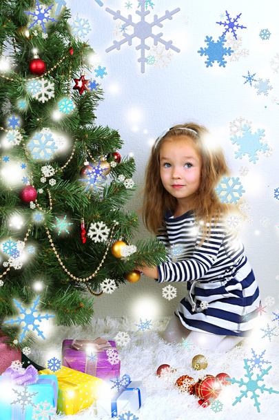 Petite fille décorant arbre de Noël avec des boules dans la chambre
 - Photo, image