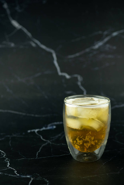 Glass of beer with ice on black marble background - Photo, Image