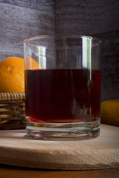 Wine, tangerines and oranges on a wooden table - Фото, изображение