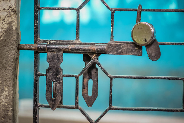 Σιδερένια ράβδος πύλη με κλειδαριά και κλειδί σε μπλε φόντο - Φωτογραφία, εικόνα