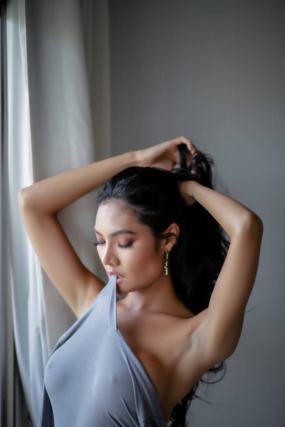 Portret van vrouw mooi naakt zeer sensueel vormen een charmante jurk bodysuit grijs kleur in de kamer. - Foto, afbeelding