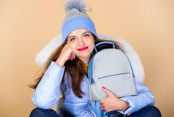 Fashion accessory. Little backpack and knitted hat. Total pastel outfit. Backpack is all you need. Girl adorable model showing her fancy leather backpack. Tender combination. Matching accessories - Foto, imagen