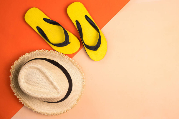 Beach hat and rubber slippers on colors background. - Photo, Image