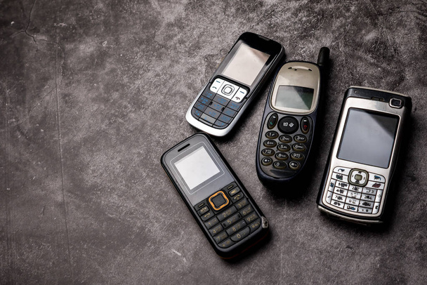 Πολλά obsoleted κινητά τηλέφωνα σε φόντο grunge. - Φωτογραφία, εικόνα
