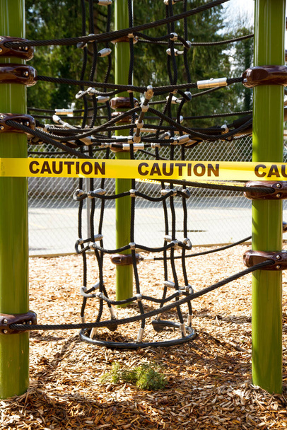 Estrutura de corda de escalada em um playground é cautela gravada fora devido a medidas de isolamento COVID-19
. - Foto, Imagem