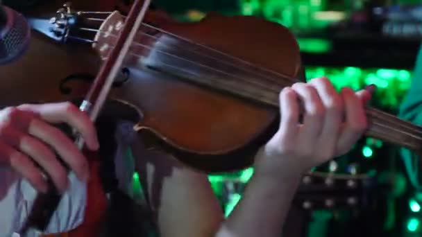 Symphonic orchestral sound conception. Close-up shot of girl violinist enthusiastically playing the violin indoors on dark background. stringed instruments at work, Full hd - Footage, Video
