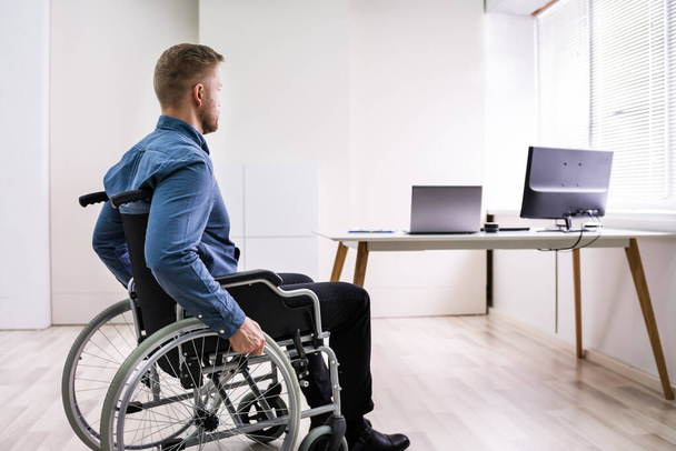 Close-up Of Businessman Sitting On Wheelchair In Office - Foto, imagen