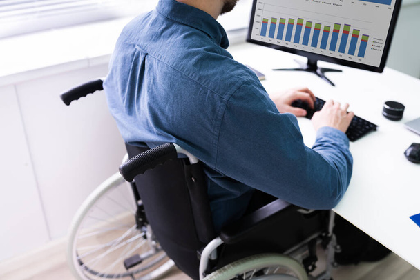 Handicapped Businessman Sitting On Wheelchair And Using Computer In Office - Fotoğraf, Görsel