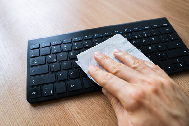 Man Wiping Computer Keyboard With Sanitizer Against Virus Infection - Foto, Imagem