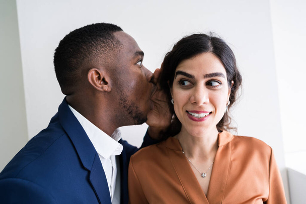 Close-up Of Businessman Whispering Into Female Partner's Ear - Photo, image