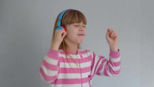Cute little girl listens music with wireless headphones - 映像、動画