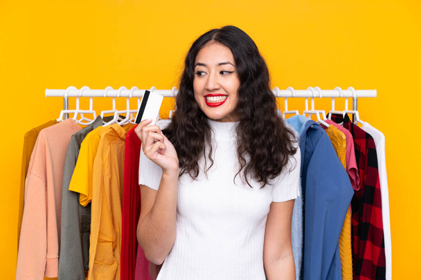 Mujer de raza mixta en una tienda de ropa y con una tarjeta de crédito - Foto, imagen