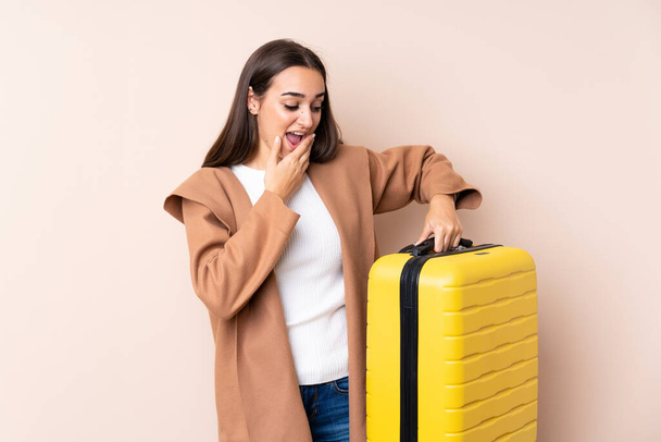 Mujer viajera con maleta con sorpresa y expresión facial impactada - Foto, Imagen