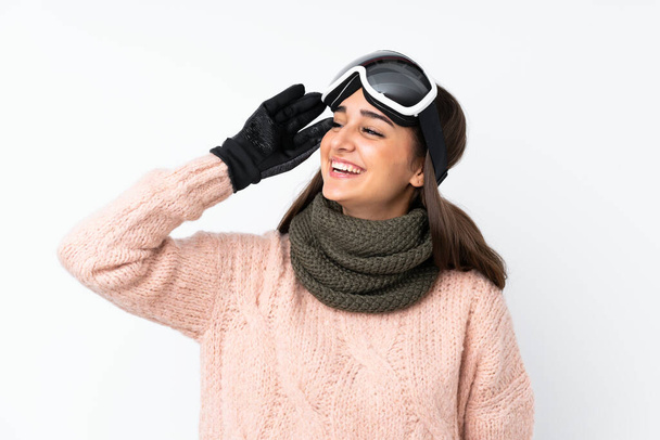 Menina esquiador com óculos de snowboard sobre parede branca isolada percebeu algo e pretendendo a solução
 - Foto, Imagem