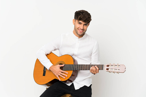 Young handsome man with guitar over isolated white background - Photo, image
