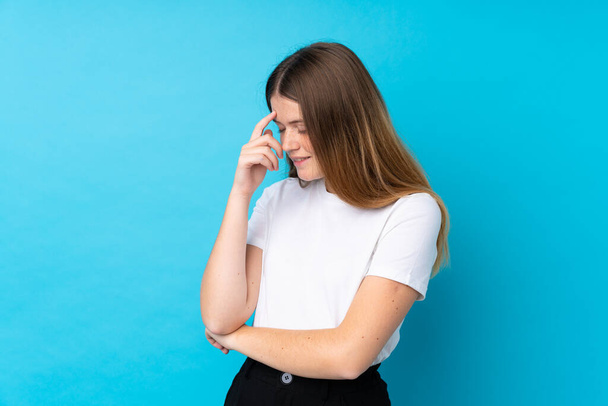 Ukrainian teenager girl over isolated blue background laughing - Foto, afbeelding
