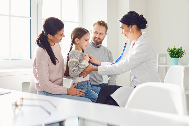 Happy family on a visit to the doctor in the office of a doctor. - Foto, imagen